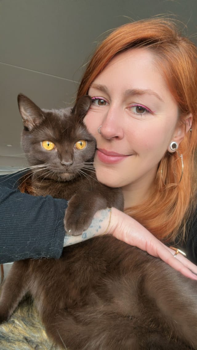 Lígia cheek to cheek with a cat